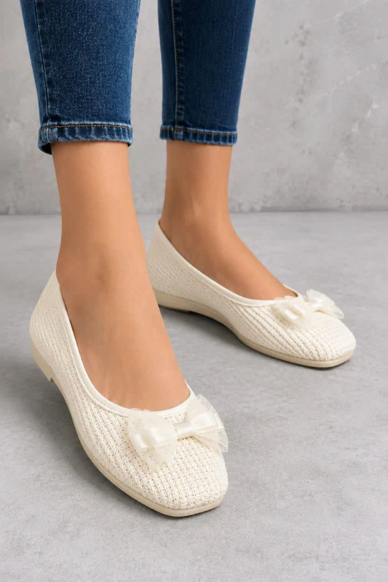 کفش تخت زنانه بافتنی کرم مدل پاپیون پوشیده شده با شلوار جین آبی نمای جانبی