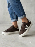 نمای کناری کتونی جیر قهوهای زنانه با زیره سفید ضخیم و لوگوی V